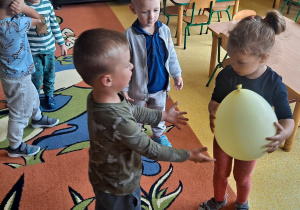 dzieci bawią się balonem na dywanie